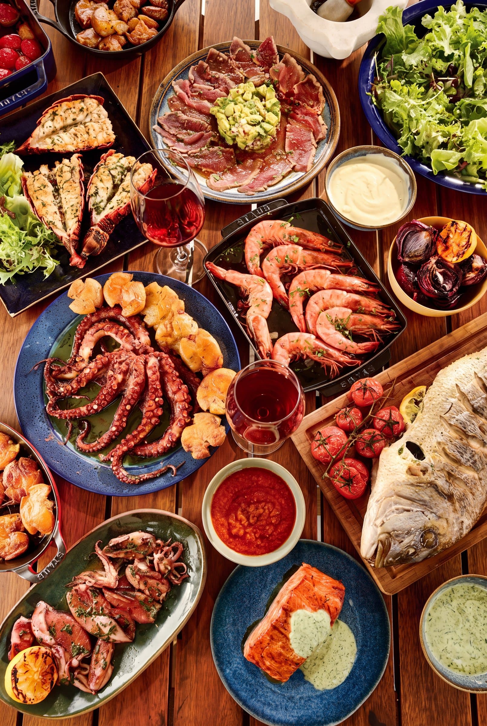 Imagem ilustrativa: mesa com polvo grelhado, camarões, lagosta, peixe assado, salmão e saladas (1 de 1)